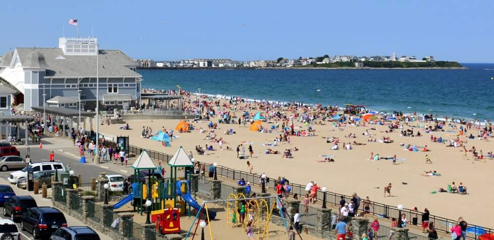 Hampton Beach in New Hampshire on a sunny day with people enjoying the beach and the playground