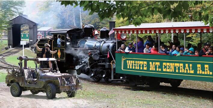 Families sitting on the white mountain central rail road car and enjoying being entertained by the wolfman at Clark's Trading Post in New Hampshire 