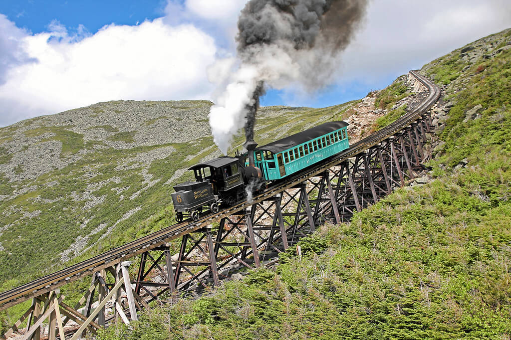 The Cog railway train driving down a steep track coming down Mount Washington in New Hampshire