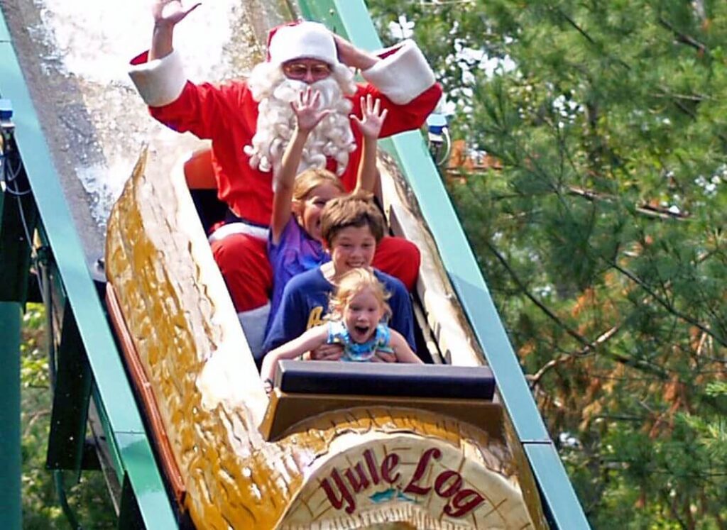 Children and Santa Clause enjoying a steep drop on the Yuld Log flume ride at Santa's Village in New Hampshire