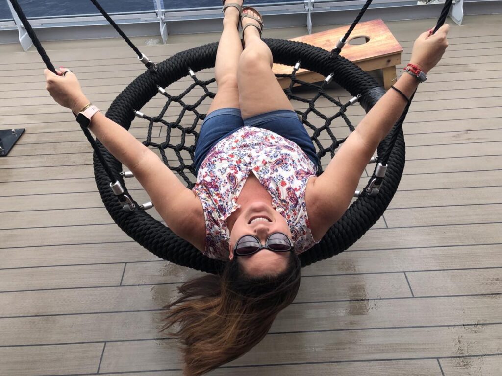 Adults playfully using a swing onboard the adults only Scarlet Lady cruise ship